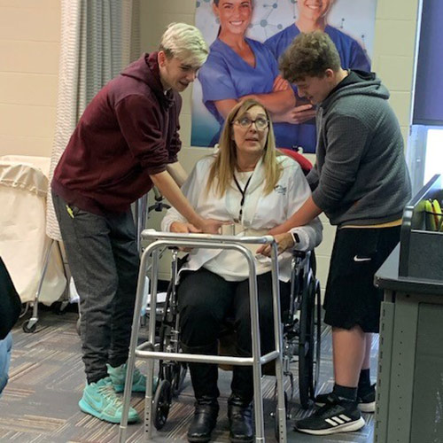 伍德蘭大學的學生們在助行器裏幫助一個病人